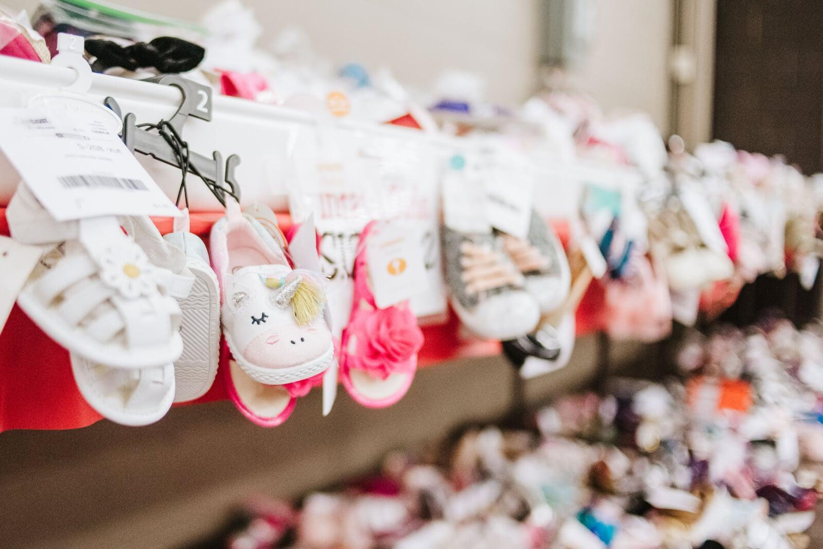 Shoes for warmer weather hanging from shelves. 